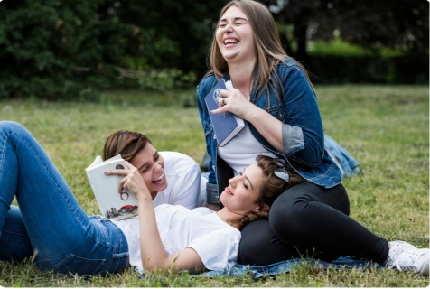 Friends laughing outdoors in sunlight